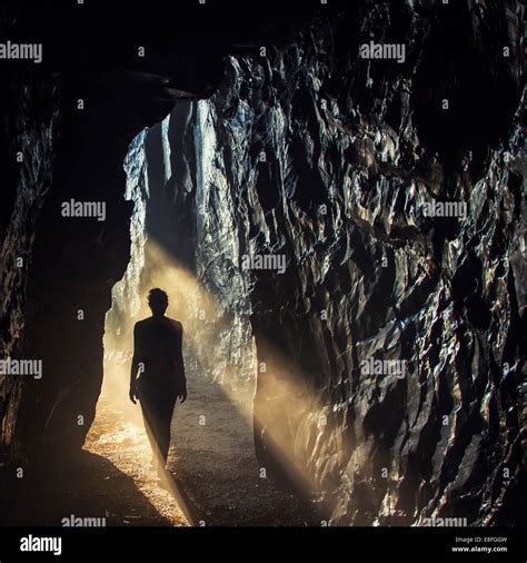 Silhouette Of A Woman Walking Into A Cave Stock Photo Alamy