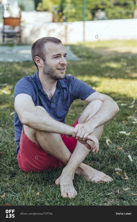 Man Sitting In Grass Barefoot Stock Photo Offset