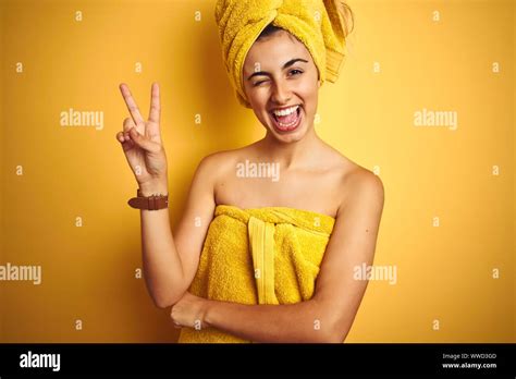 Young Beautiful Woman Wearing A Shower Towel After Bath Over Yellow