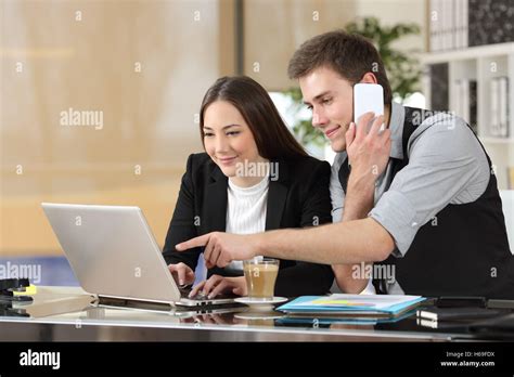 Two Coworkers Working Together Online Giving Instructions With A Laptop