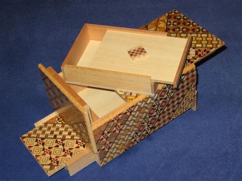 Two Wooden Boxes With Different Patterns On Them Sitting On A Blue