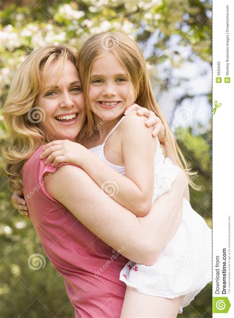 Mother Holding Daughter Outdoors Smiling Stock Photo - Image of ...