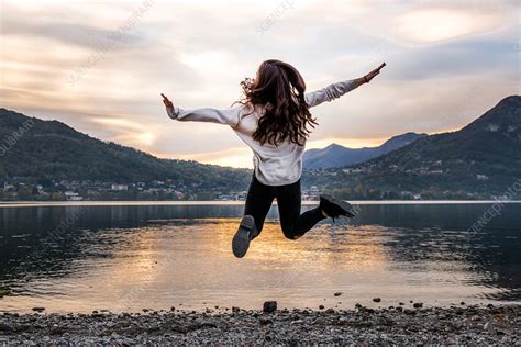 Rear View Of Woman Jumping Mid Air At Dusk Italy Stock Image F021 8966 Science Photo Library