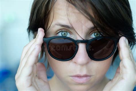 A Disheveled Girl Without Makeup Takes Off Her Black Sunglasses In