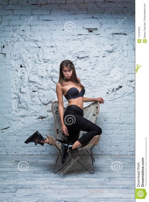 Seductive Brunette Woman Posing On A Modern Chair Stock Photo Image