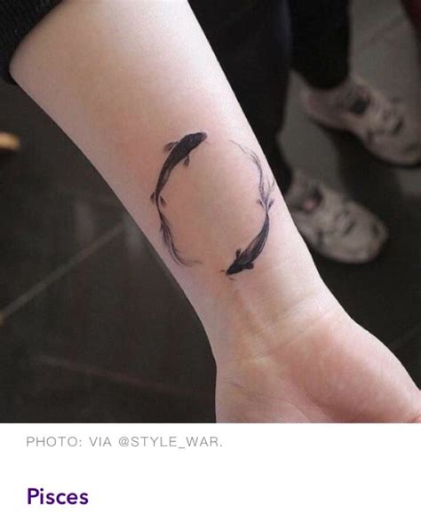 A Womans Arm With A Small Black Fish Tattoo On It