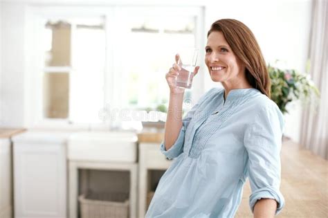 Keeping Hydrated A Young Man Drinking A Glass Of Water Stock Photo