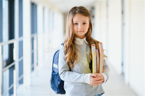 Front View Of Little Beautiful School Girl Among Corridor At School