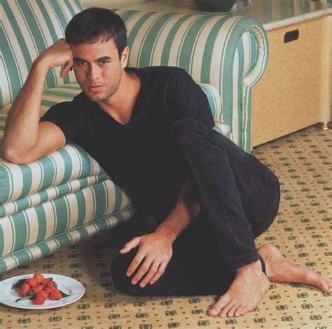 A Man Sitting On The Floor Next To A Plate Of Strawberries In Front Of Him