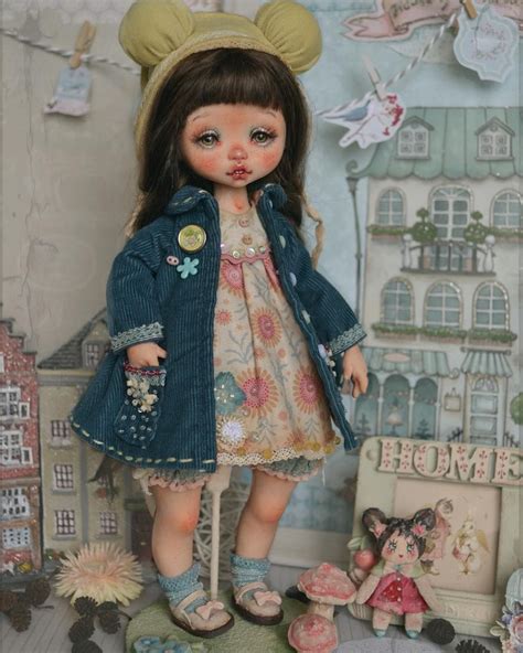 The Doll Is Wearing A Blue Jacket And Dress