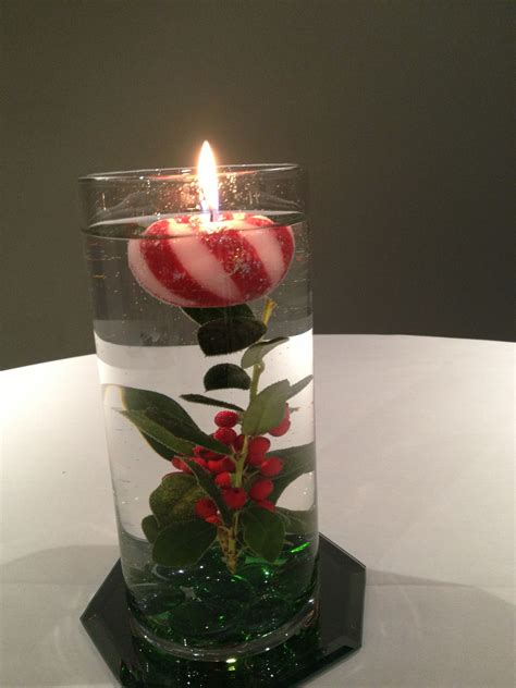 Floating Candle In Cylinder Vase With Holly And Glass Marbles Atop An