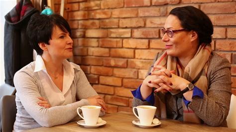 Two Women Talking In Cafe And Drinking Coffee Stock Video Footage