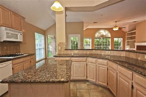These oak cabinets kitchen come in varied designs, sure to complement your style. Pickled Oak with Baltic Brown Granite | Oak cabinets, Oak ...