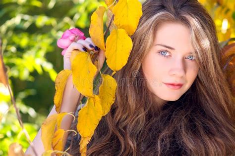Beautiful Model With Autumn Leaves And Fall Yellow Garden Background