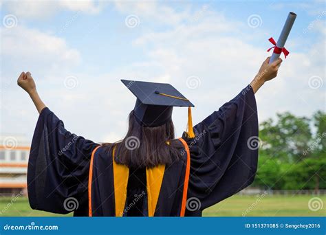 Rear View Of A Female University Graduate Stands And Holds Degree