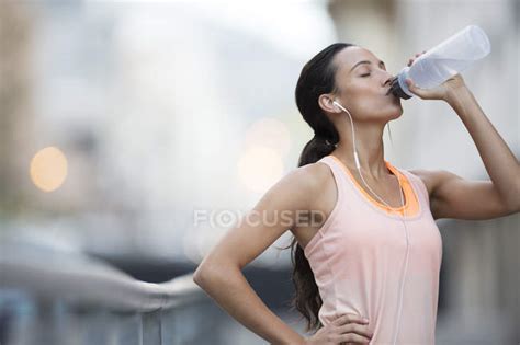 Woman Drinking Water After Exercising On City Street — Recreation