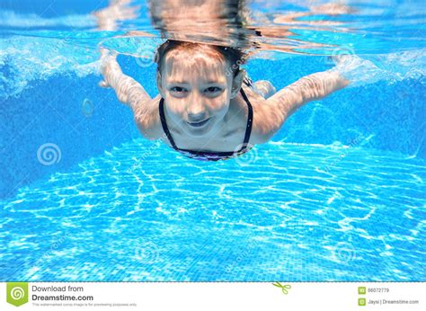 Ребенок плавает в бассейне подводном счастливая активная девушка имеет