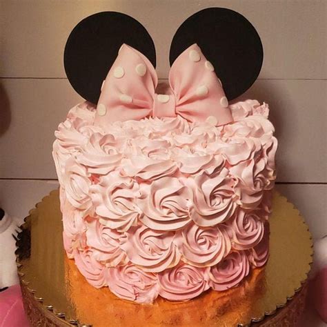A Cake Decorated With Pink Frosting And Minnie Mouse Ears