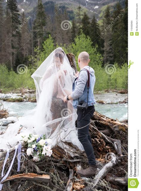 A Wedding Photographer Takes Pictures Of The Bride And Groom In Nature