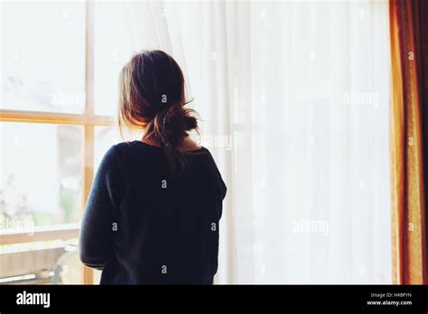 Woman Looking Out Of Window Stock Photo Alamy