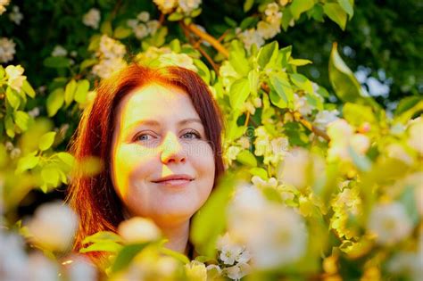 A Girl With Red Hair In A Park Near A Flowering Apple Tree Fat Woman Posing In Nature Stock