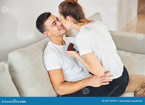 Loving Couple Cuddling On Sofa And Eating Chocolate Cake Stock Image