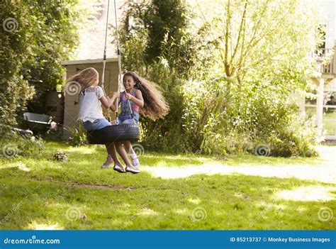 Two Girls Playing Together On Tire Swing In Garden Stock Image Image Of Copy Oxfordshire