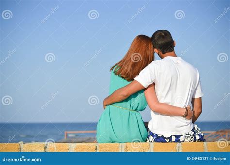 romantic happy couple looking at sea sitting on sandy beach and embracing stock image image of
