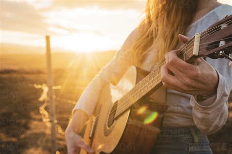 Iceland Woman Playing Guitar At Sunset Stock Photo