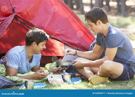 Two Young Men Cooking On Camping Stove Outside Tent Stock Image Image