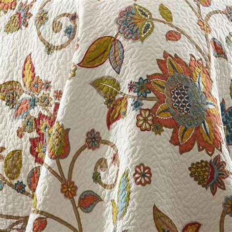 An Image Of A Quilted Bed With Flowers And Leaves On The Coverlets