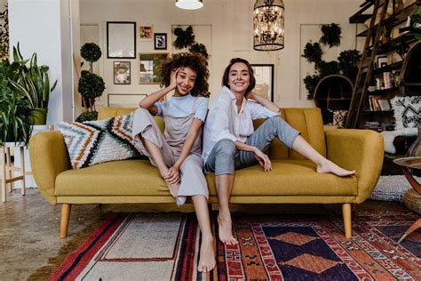 Portrait Of A Cheerful Lesbian Couple At A Yellow Couch Premium Image