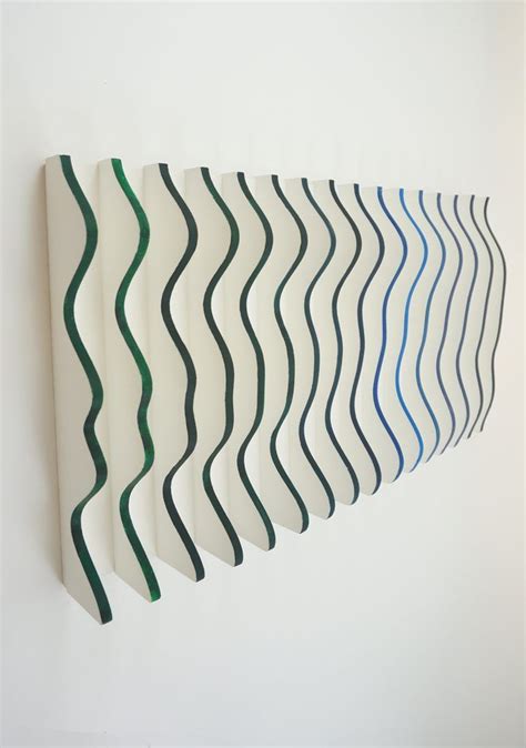 An Art Piece With Wavy Lines Painted On Its Side Against A White Wall