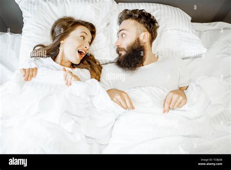 Portrait Of A Young Couple Feeling Surprised And Shocked Lying Together