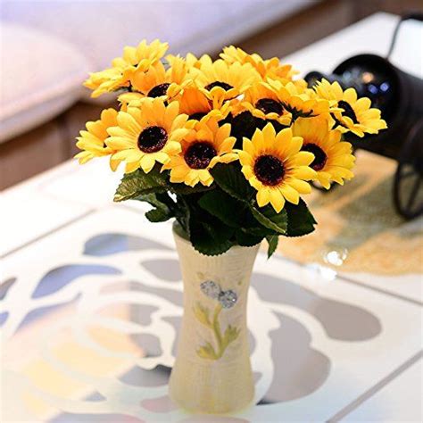 A Vase Filled With Yellow Sunflowers Sitting On Top Of A Table Next To