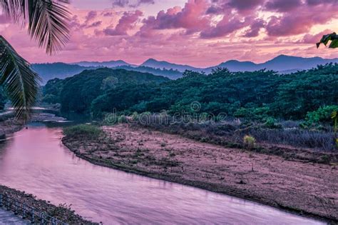 Sunset Over The Thai Burmese Mountains With River And Palm Tree Stock