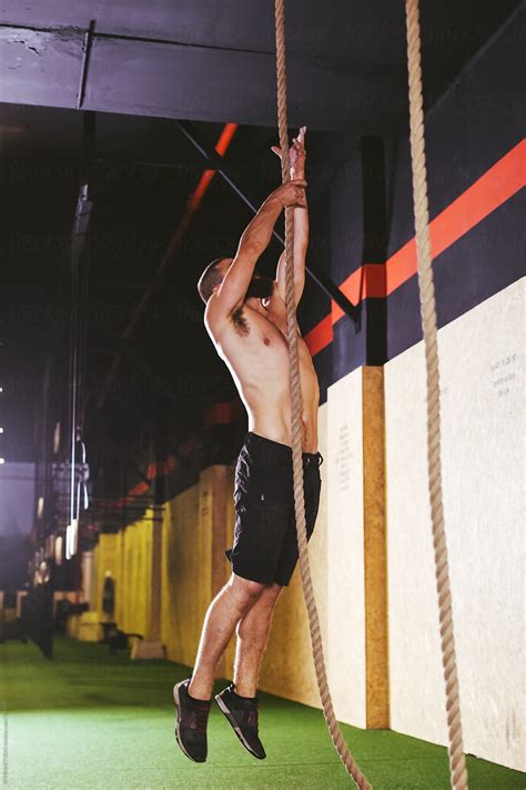 Man Climbing A Rope In A Gym Box By Stocksy Contributor