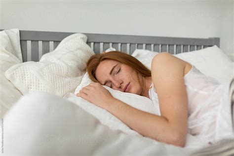 redhead woman sleeping in the bed by stocksy contributor javier pardina stocksy