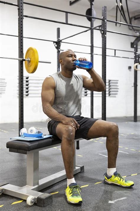 Black Male Athlete Drinking Water After Workout In Gym Stock Photo