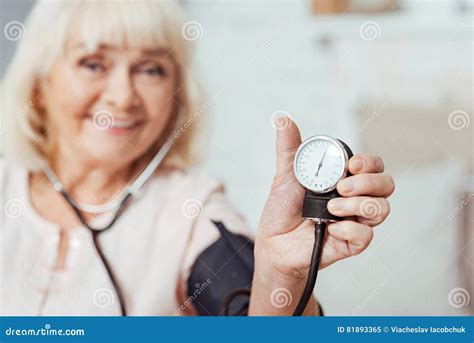 Pleasant Smiling Elderly Woman Measutring Blood Pressure Stock Image