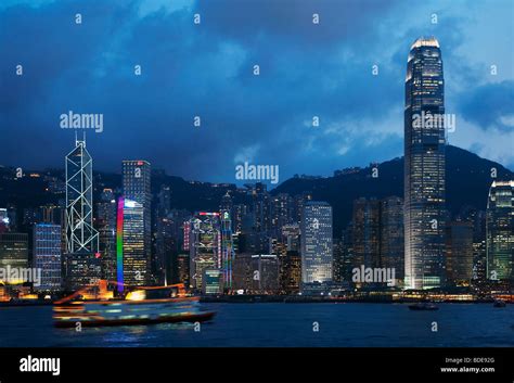 View Across Victoria Harbour Of High Rise Buildings At Night In Hong