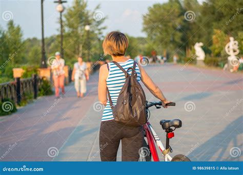 Young Woman Walking With A Bicycle And Backpack On The Promenade Stock Image Image Of Pretty
