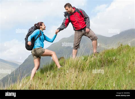 Attractive Hiker Helping His Girlfriend Uphill Stock Photo Alamy