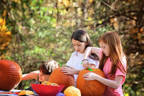 Three Young Children Carving Pumpkins Outdoors Photograph By Cavan