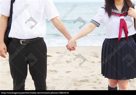 Junges Paar händchenhaltend am Strand Mittelteil Lizenzfreies Foto