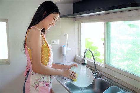 Asian Girl Washing Up A Dish In Her Kitchen Photograph By Anek Suwannaphoom