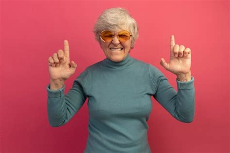 Free Photo Irritated Old Woman Wearing Blue Turtleneck Sweater And Sunglasses Biting Lip