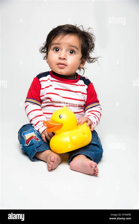 Indian Baby Boy Playing Over Over White Background And Looking At
