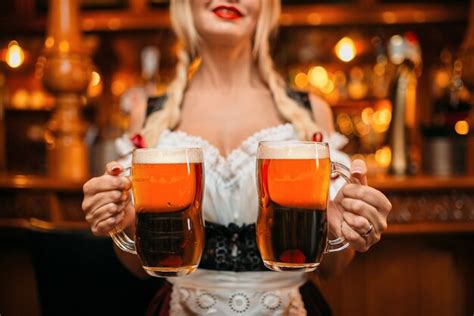 Premium Photo Sexy Waitress Holds Two Mugs Of Fresh Beer In Pub