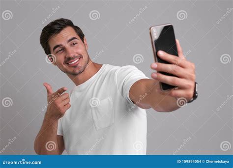 Handsome Young Man Taking Selfie With Smartphone On Background Stock